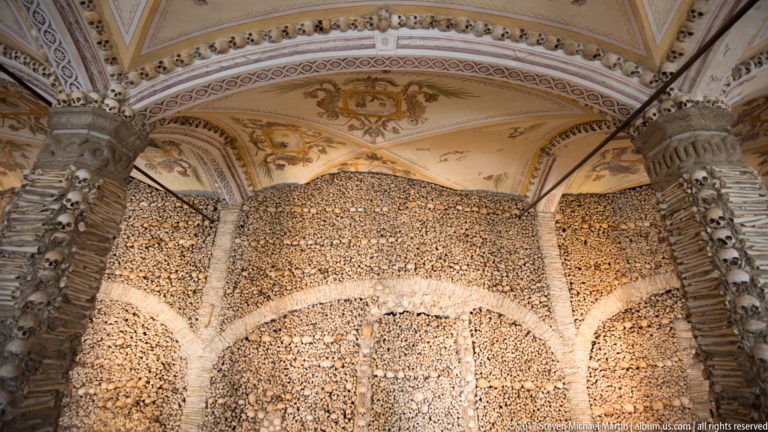 Bone-lined arches and walls densely packed with human skulls and long bones inside Évora's Chapel of Bones.