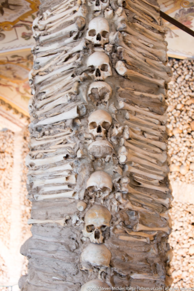 Bone-covered pier with a vertical row of human skulls inside Évora's Chapel of Bones.