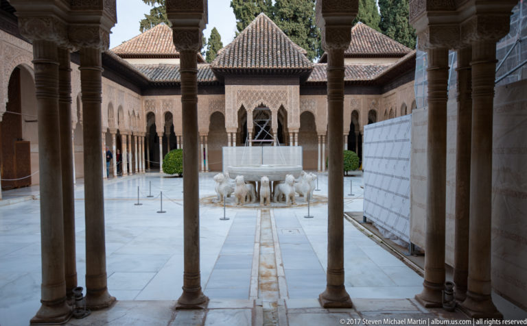 Fountain of the Lions centered between slender columns in the Court of the Lions, with arcades and pavilion behind.