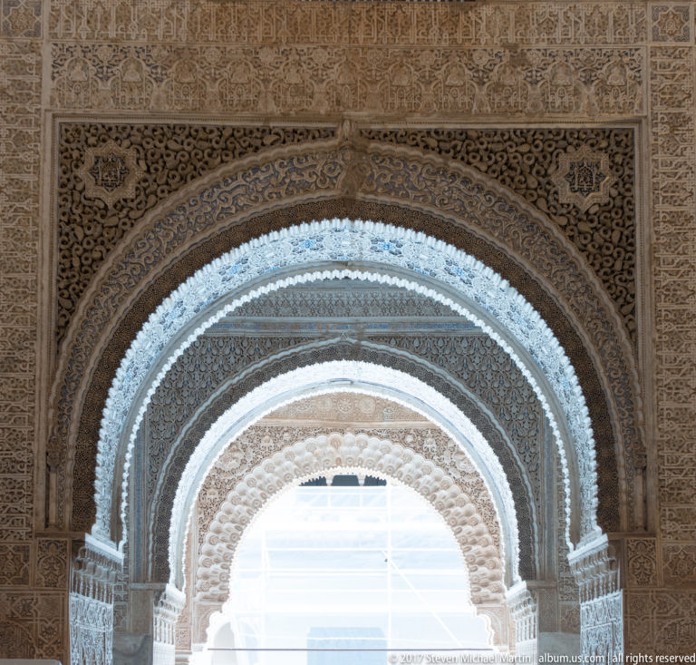 Successive richly carved muqarnas arches with Arabic epigraphic and vegetal plaster decoration in the Sala de los Reyes at the Alhambra.