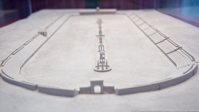 Scale model of an elongated Roman circus with central barrier and seating arranged around the arena.