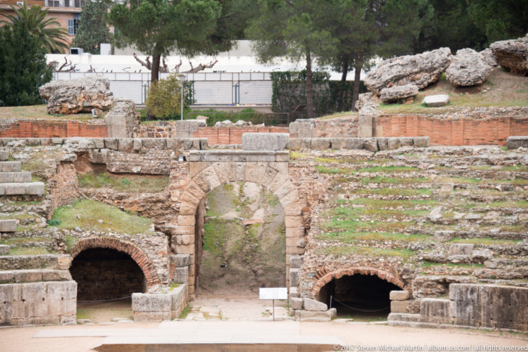 Central arched entrance flanked by smaller vaulted passages beneath the stone seating of Mérida's Roman amphitheatre.