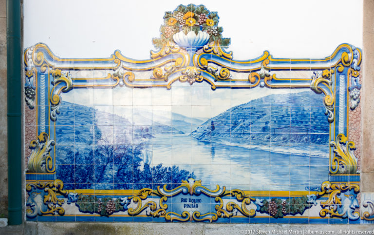 Azulejo panel labeled Rio Douro Pinhão, showing a broad river between steep hills with a small boat near shore.