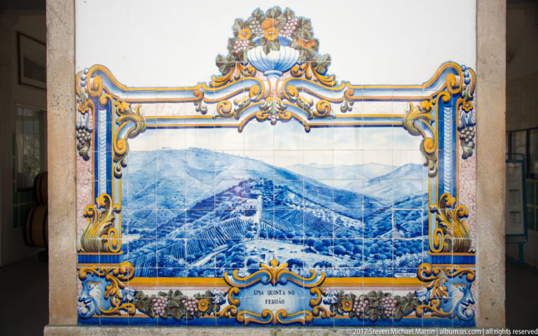 Ornate azulejo panel labeled Uma Quinta no Douro, showing estate buildings and vineyard hills in blue and white.