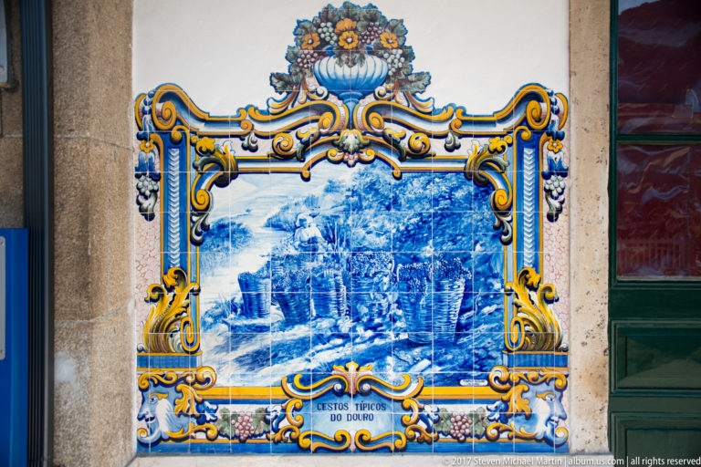Azulejo panel labeled Costumes Típicos do Douro, showing people and laden animals gathered on a rural route.