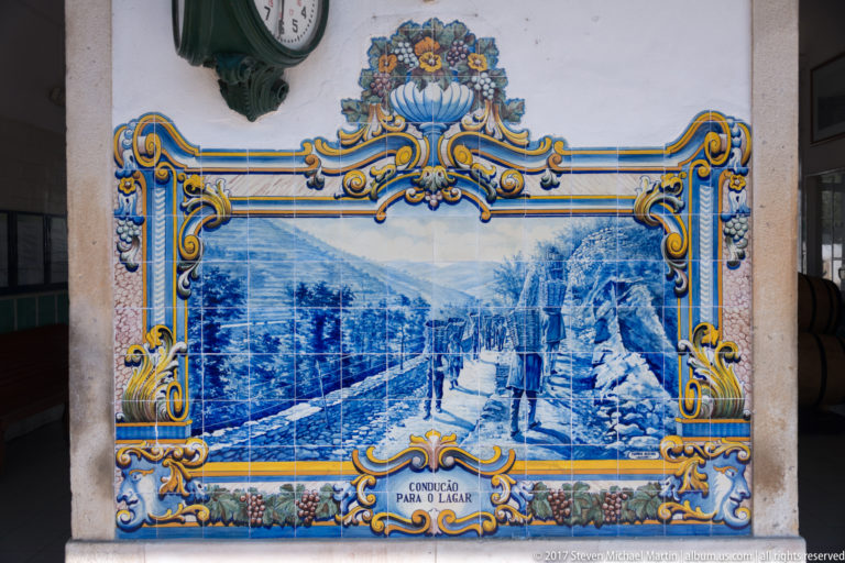 Azulejo panel labeled Condução para o Lagar, showing workers and a laden animal moving along a rocky rural path.