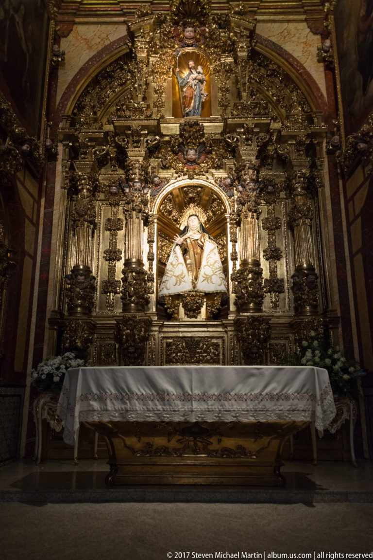 Gilded Baroque altar centered on a statue of Saint Teresa of Ávila in Carmelite dress.