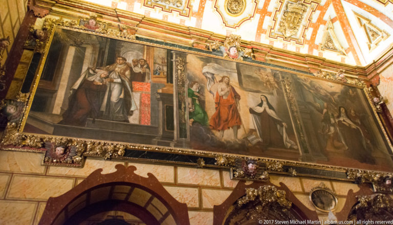 Large multi-figure religious canvas above an arch in the Saint Teresa complex in Ávila.