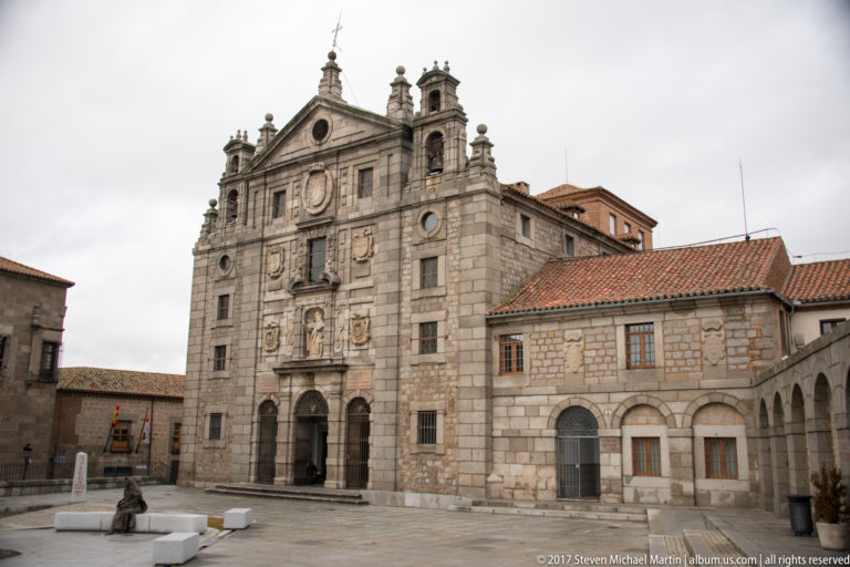 Stone Baroque façade of the Basilica of Saint Teresa facing an open plaza in Ávila.