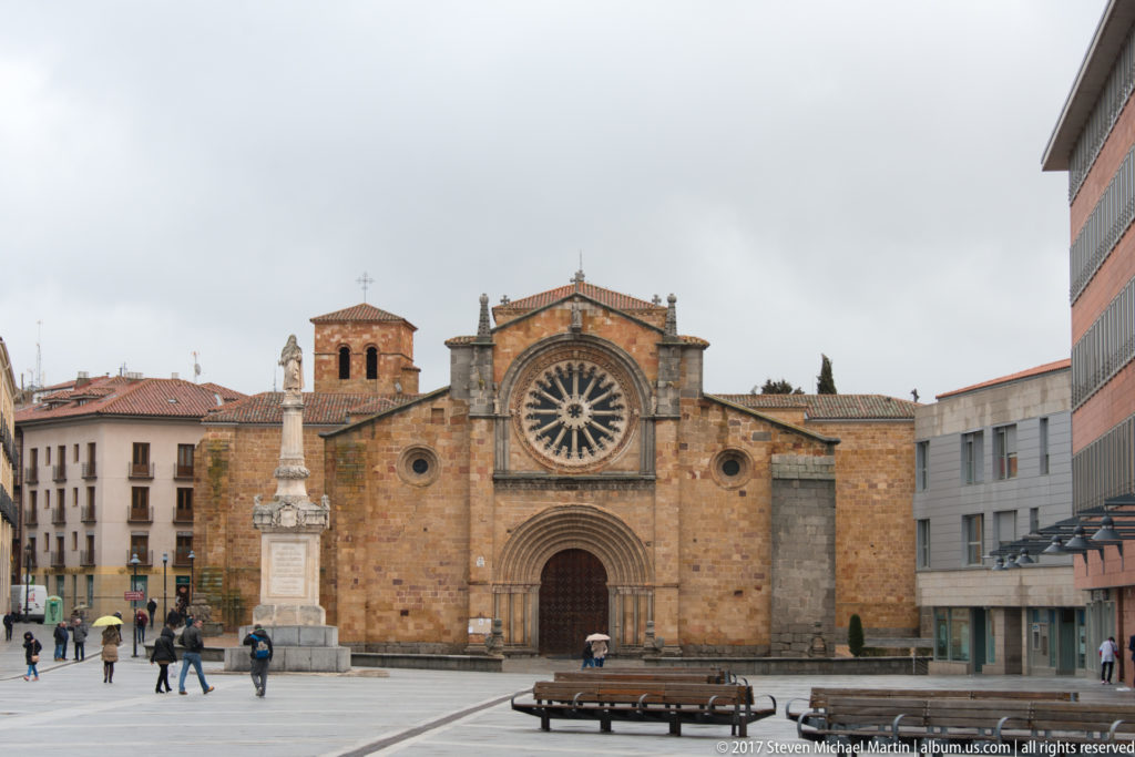 West façade of the Basilica of San Vicente with twin towers, rose window and recessed Romanesque portal.