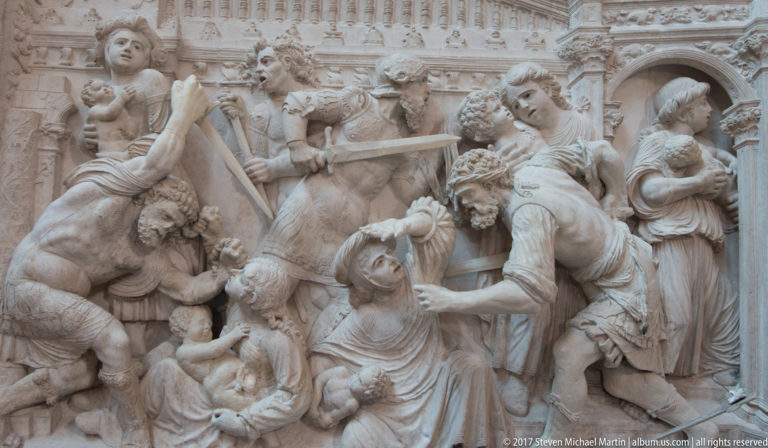 Close detail of a crowded carved biblical scene on the Renaissance retrochoir of Ávila Cathedral.
