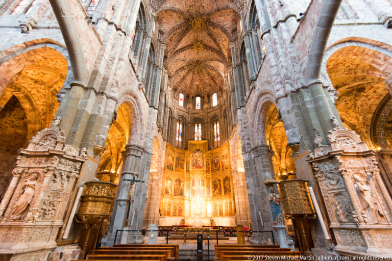 Gothic sanctuary of Ávila Cathedral with the monumental painted and gilded high altarpiece filling the apse.