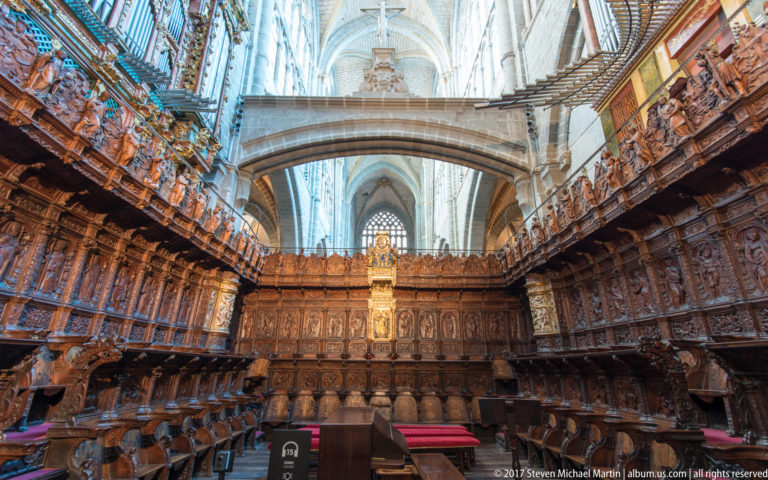 Double tiers of richly carved wooden choir stalls inside Ávila Cathedral.