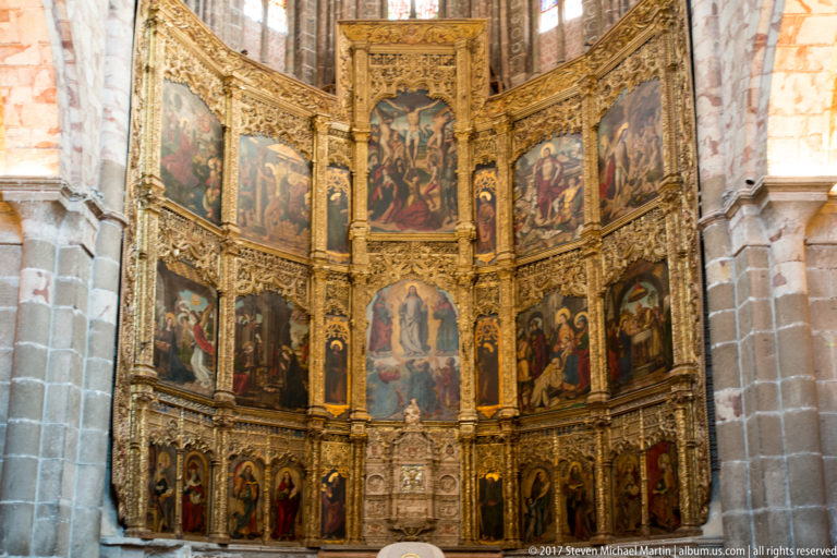 Close frontal view of painted sacred scenes divided by gilded architecture on Ávila Cathedral’s high altarpiece.