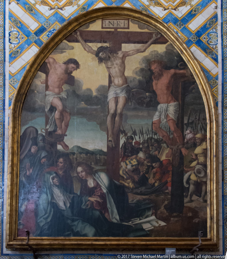 Arched Crucifixion painting with Christ between two thieves, mourners below, and soldiers in the background.