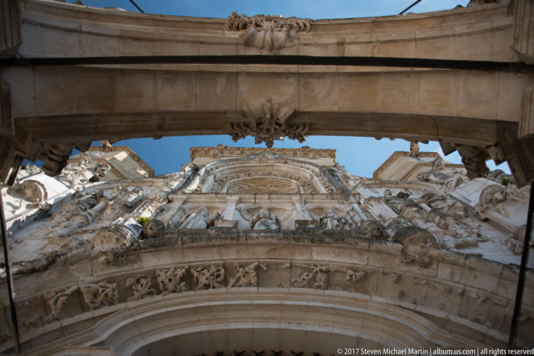 Upward view through an outer arch toward the layered carved portal of Santa Cruz Church.
