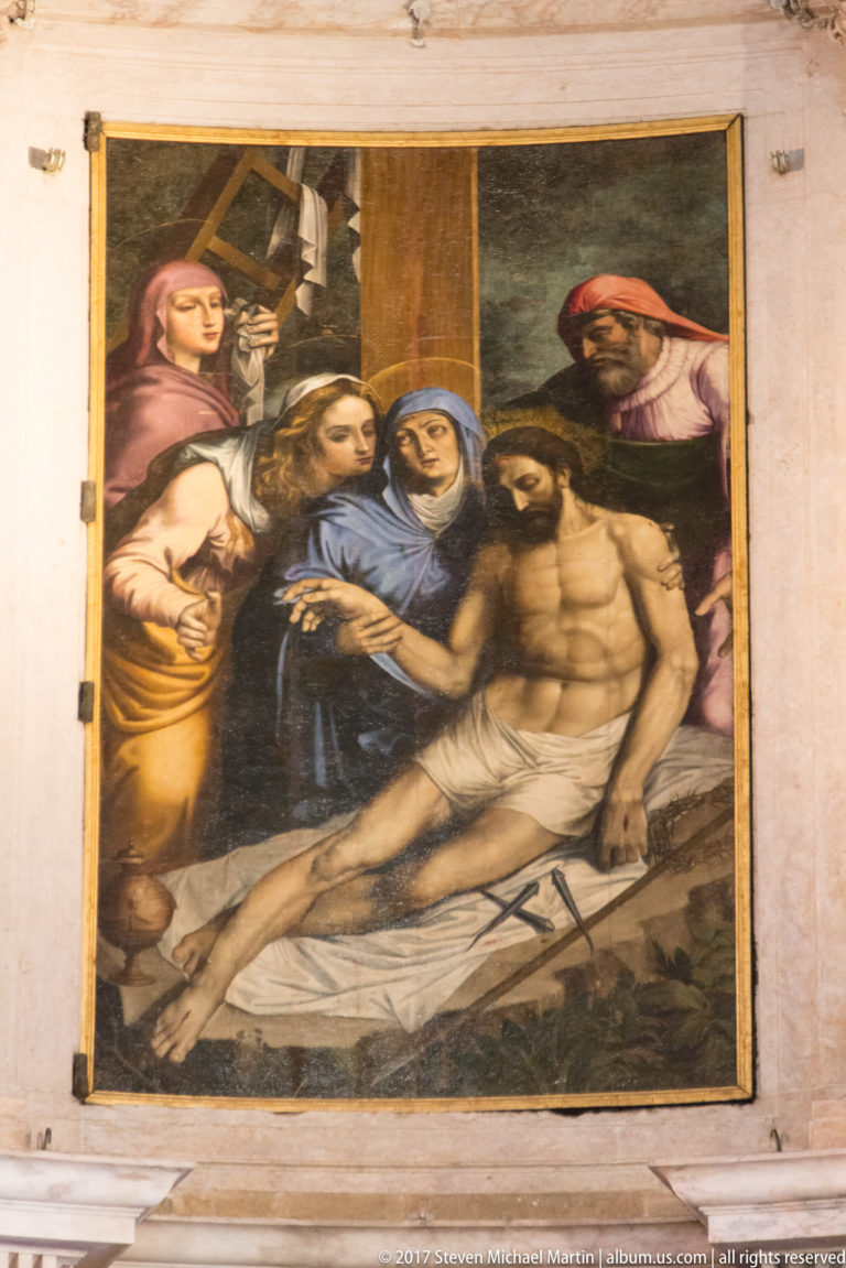 Religious painting of the dead Christ supported by mourners, with grieving women gathered at left in the Jerónimos Monastery.