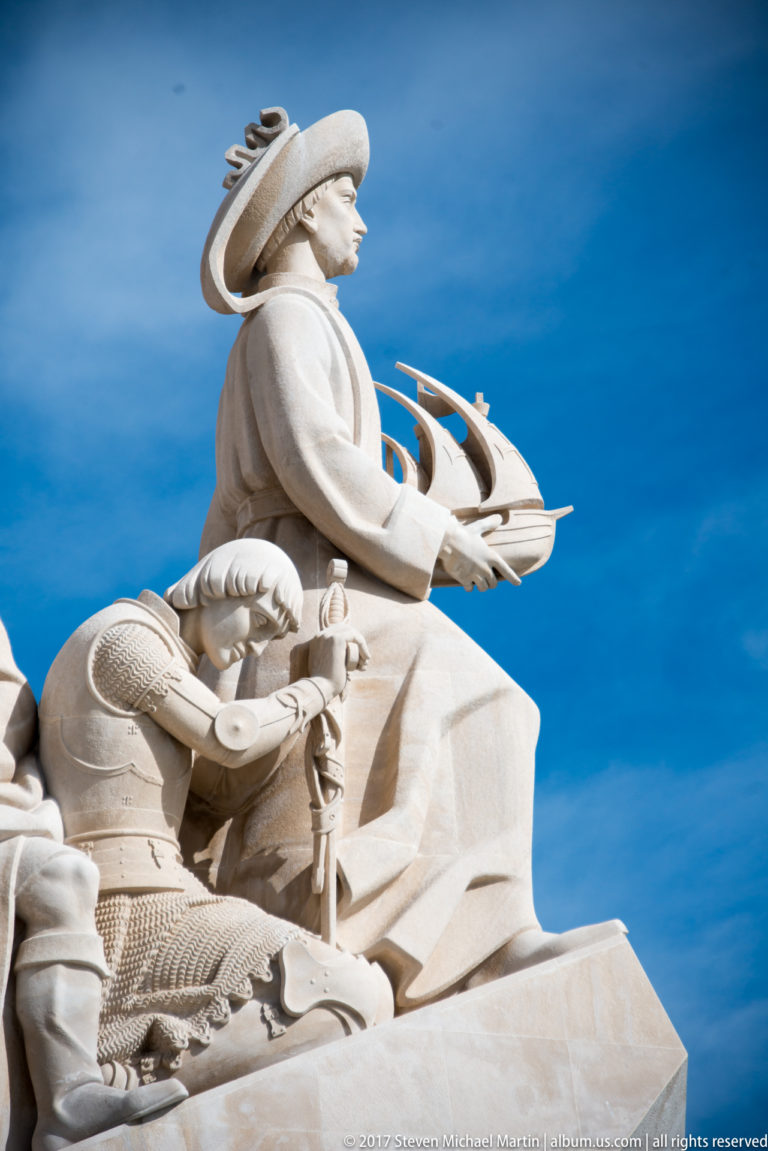 Stone figure of Prince Henry the Navigator holding a model ship at the prow of the Monument to the Discoveries.