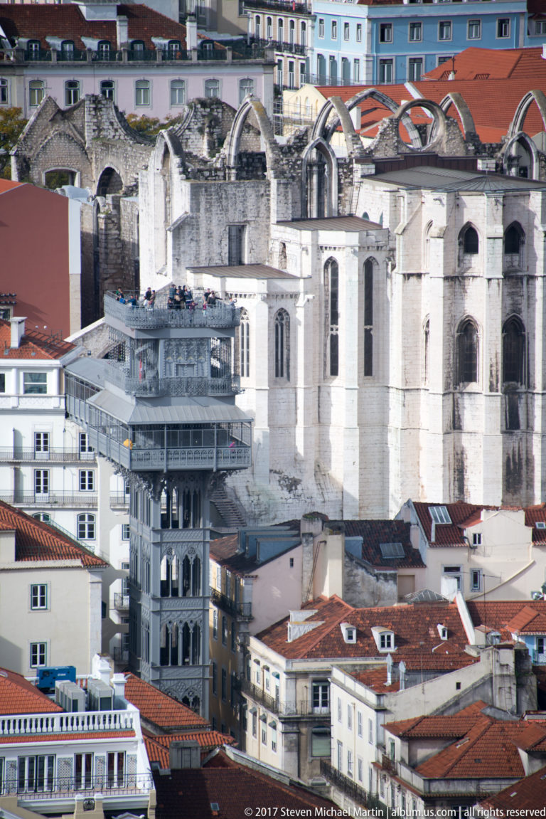 Santa Justa Lift rising among Lisbon rooftops with the roofless Carmo Convent immediately behind.