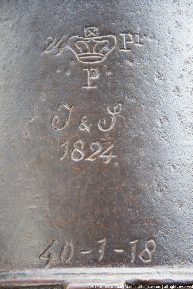Close view of a worn surface incised with a crown-like emblem, letter P, date 1824, and other markings.