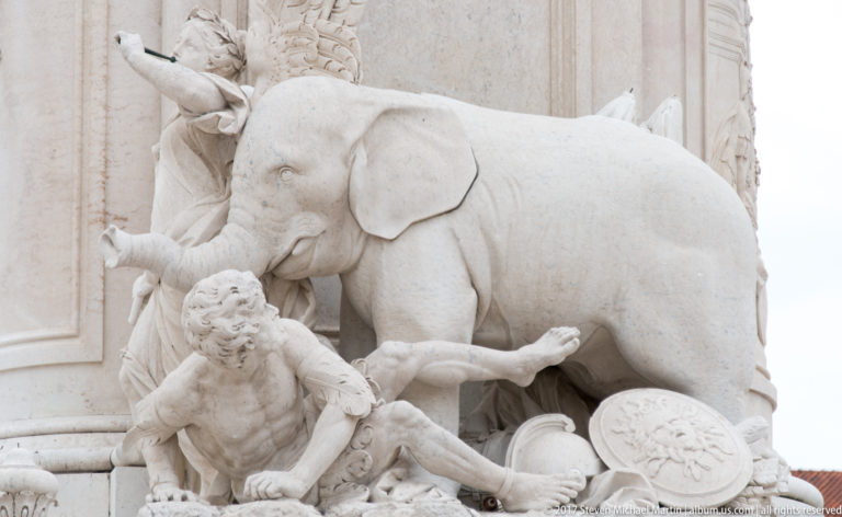 Stone elephant and reclining male figure forming part of the sculptural base of King José I's monument.