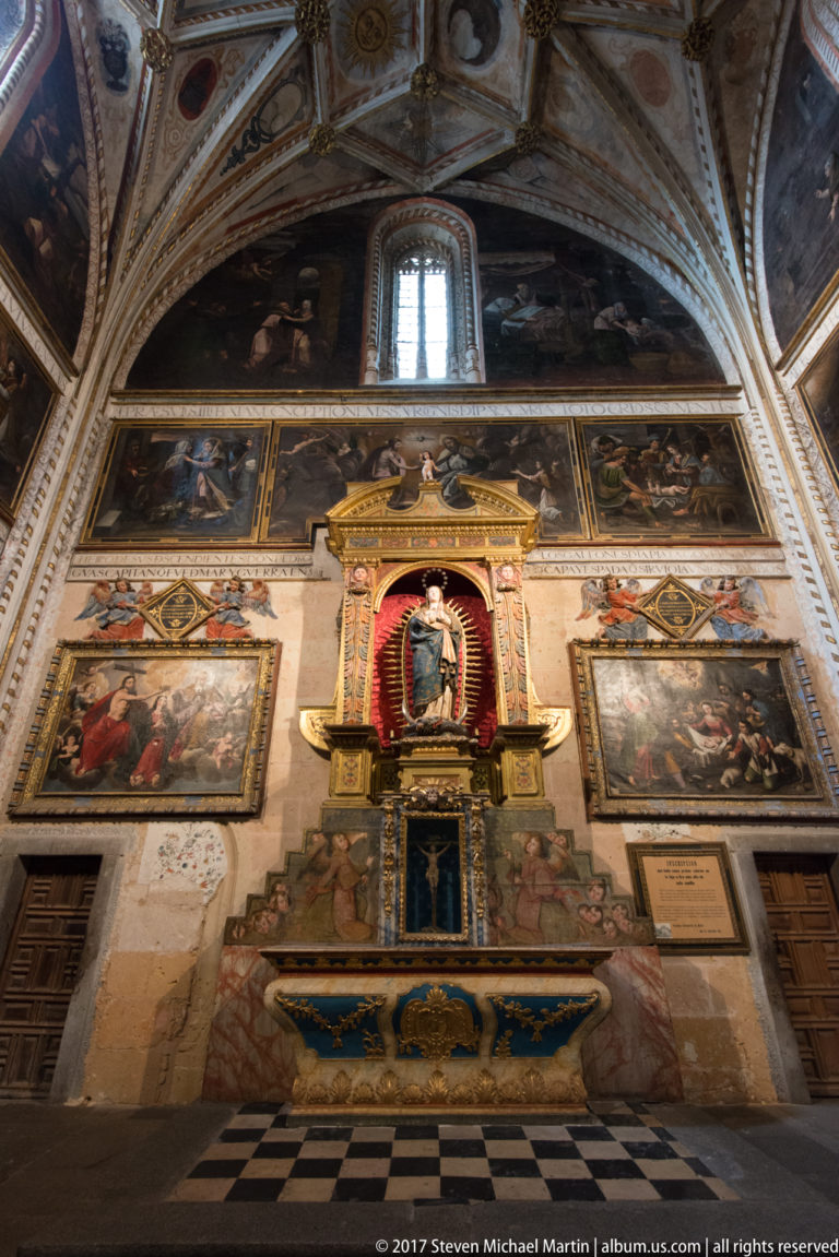 Cathedral chapel densely decorated with wall and ceiling paintings, large narrative canvases, and a central gilded devotional shrine.