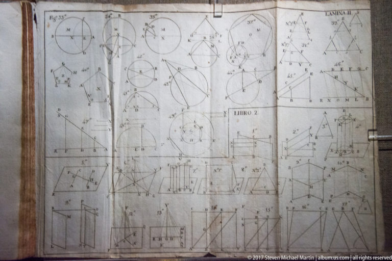 Open aged folio filled with geometric diagrams of circles, triangles, angles, and measured line constructions across two pages.