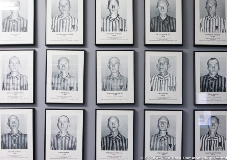 Grid of framed Auschwitz prisoner portraits, each labeled with a name, prisoner number and biographical details.