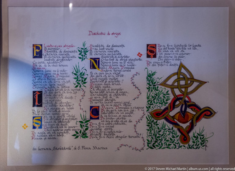 Framed calligraphic page with colored initials, leafy decoration, and a large interlaced ornamental motif.
