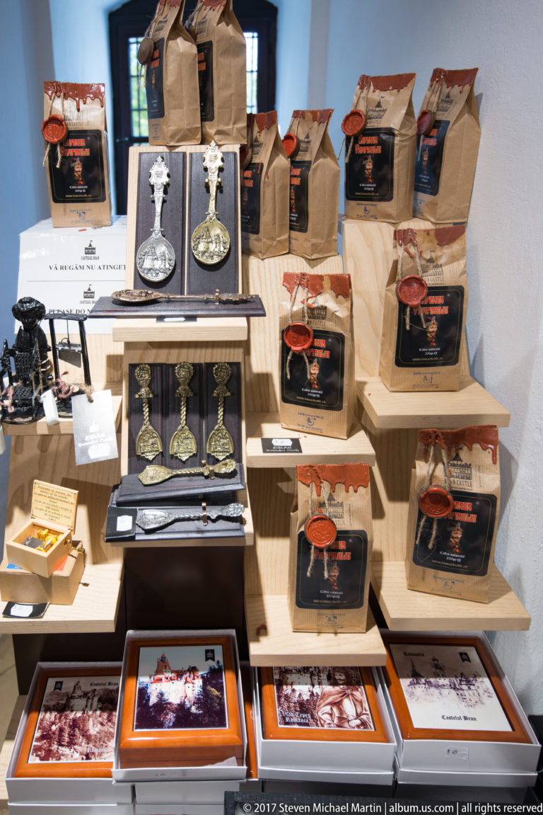 Retail display with decorative goblets, boxed souvenirs, printed images, and packaged Bran Castle merchandise.