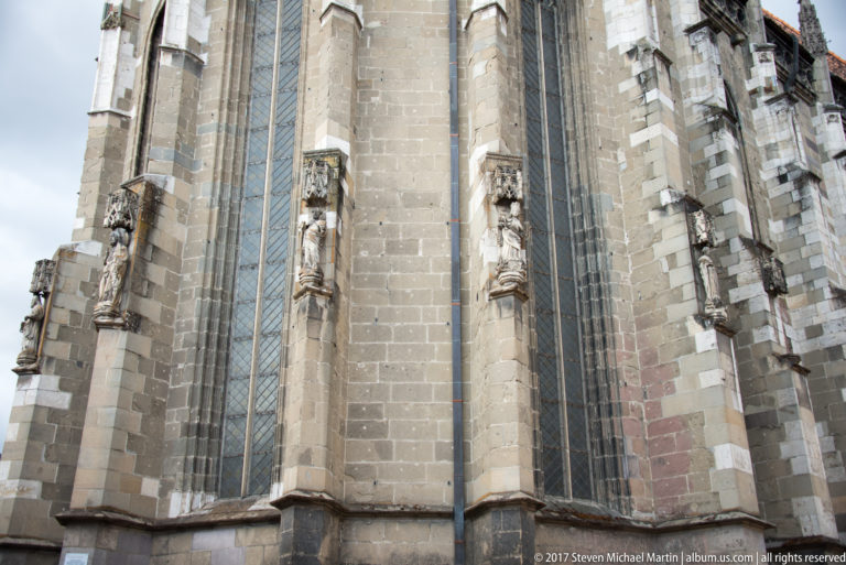 Close exterior view of the Black Church showing tall Gothic windows, stone buttresses, and sculptural niches.