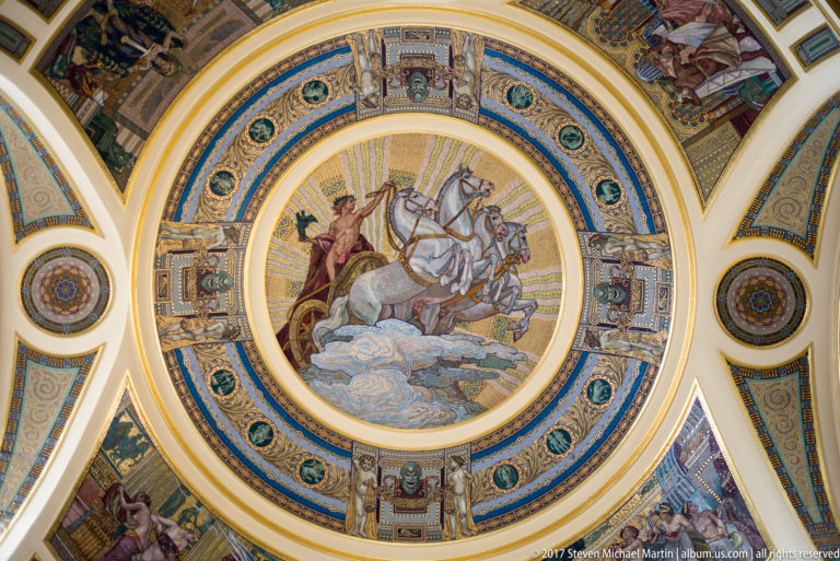 Ornate circular mosaic ceiling with central horse-and-rider scene, blue and gold borders, and surrounding classical figures.