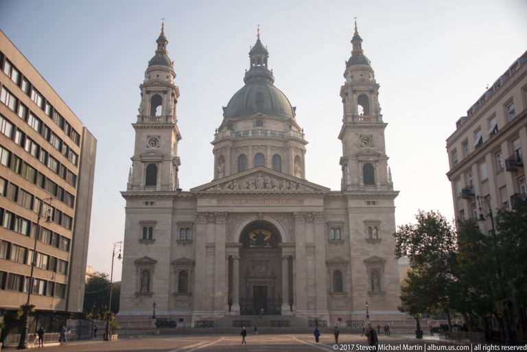 Full frontal view of St. Stephen’s Basilica with central dome, twin towers, classical portico, and open plaza.
