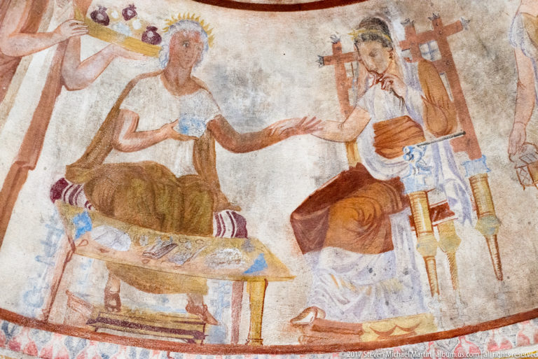 Painted seated figures beside a low table with vessels, including a figure on an ornate chair and attendants at the edges.