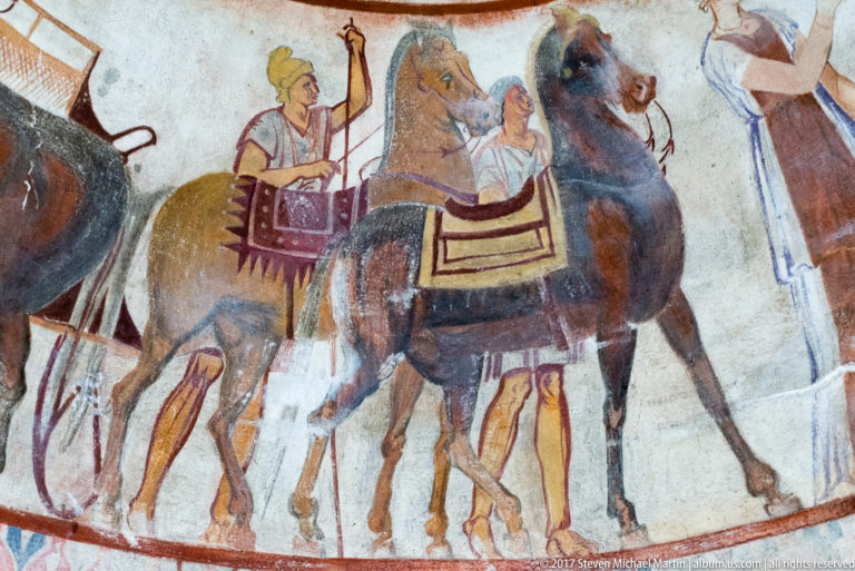 Painted mounted procession with overlapping brown and dark horses, riders, patterned saddlecloths, and harness details.