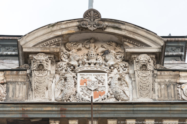 Large double-headed eagle relief surrounding a central coat of arms on an ornate historic façade.