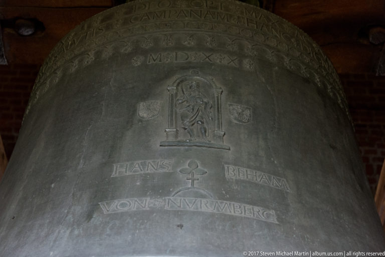 Close view of the Sigismund Bell showing cast inscriptions, relief decoration, Hans Beham's name, and the date MDXX.