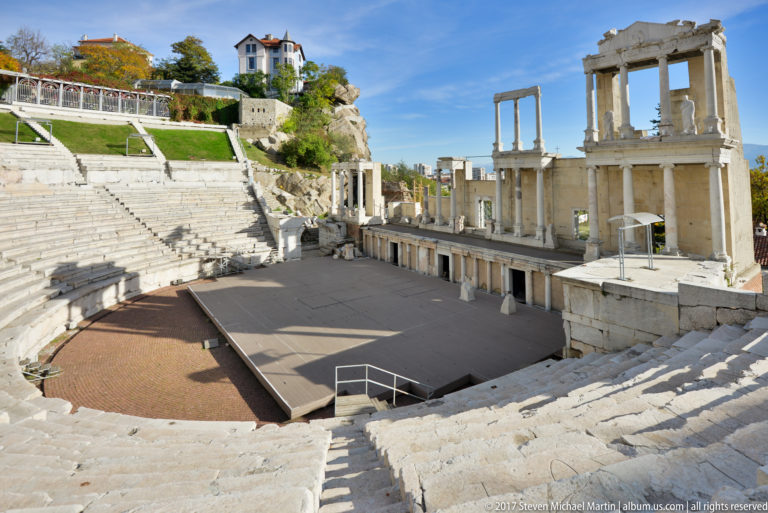 Semicircular stone seating descends toward the stage and columned stage building of Plovdiv’s ancient Roman theatre.