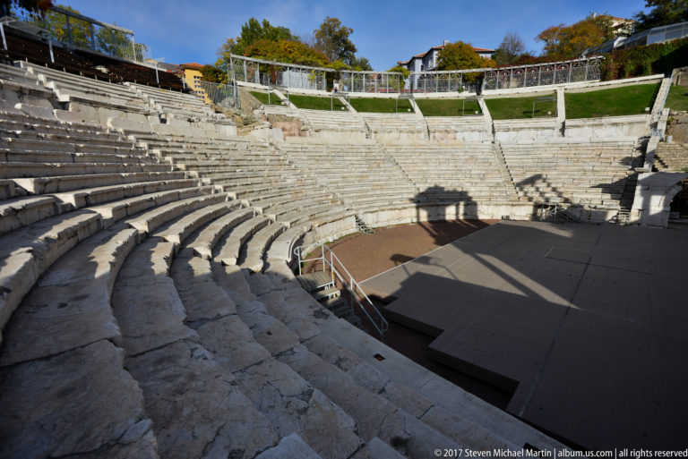 Weathered concentric stone seating curves steeply around the stage area of Plovdiv’s ancient Roman theatre.