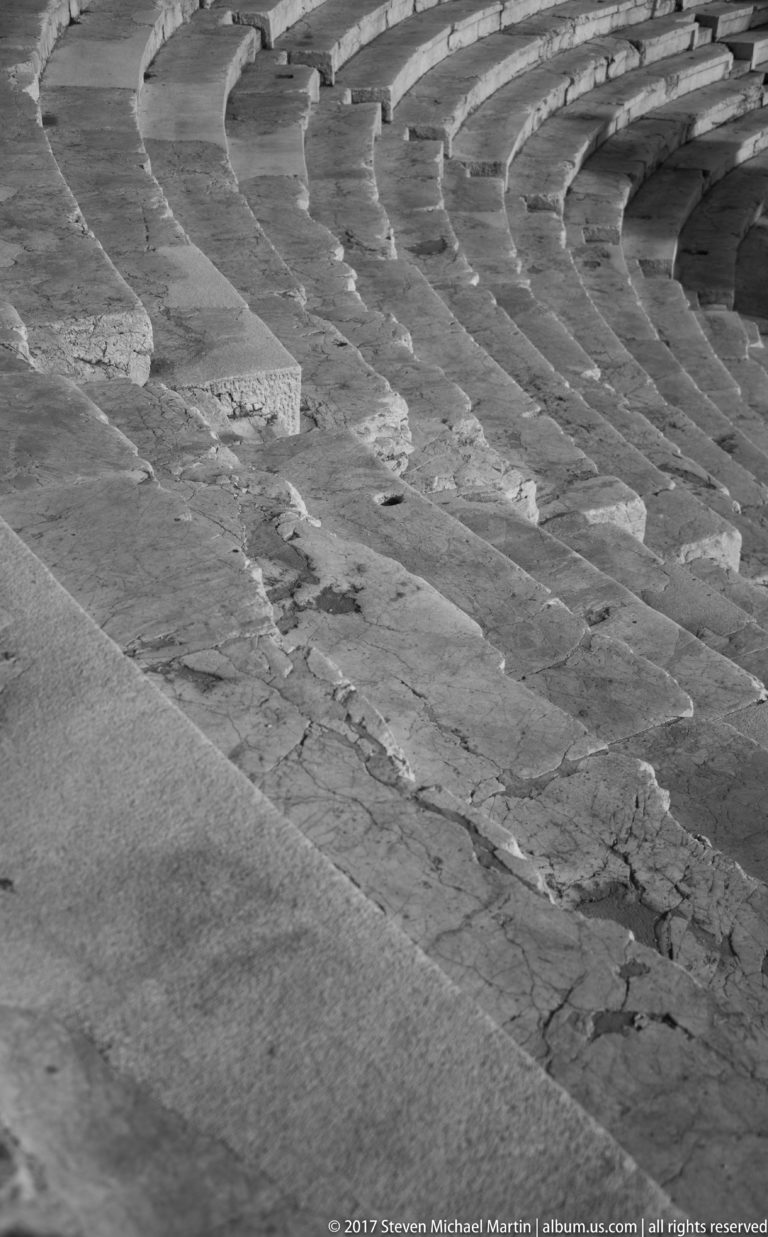 Close black-and-white view of cracked and weathered concentric stone seating in Plovdiv’s ancient Roman theatre.
