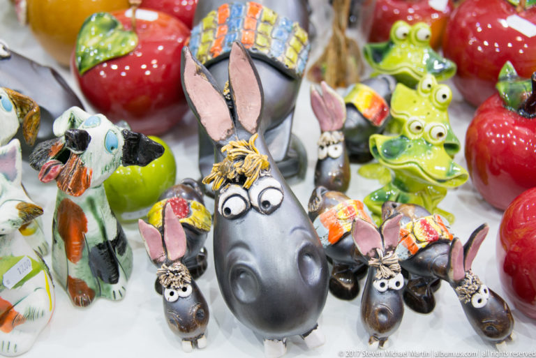 Cluster of colorful ceramic donkey figurines with long ears, large eyes, and hand-painted decorative details on a shop display.