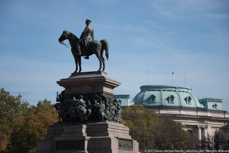 Equestrian statue on a tall bronze and stone monument with sculptural figures around the pedestal in central Sofia.