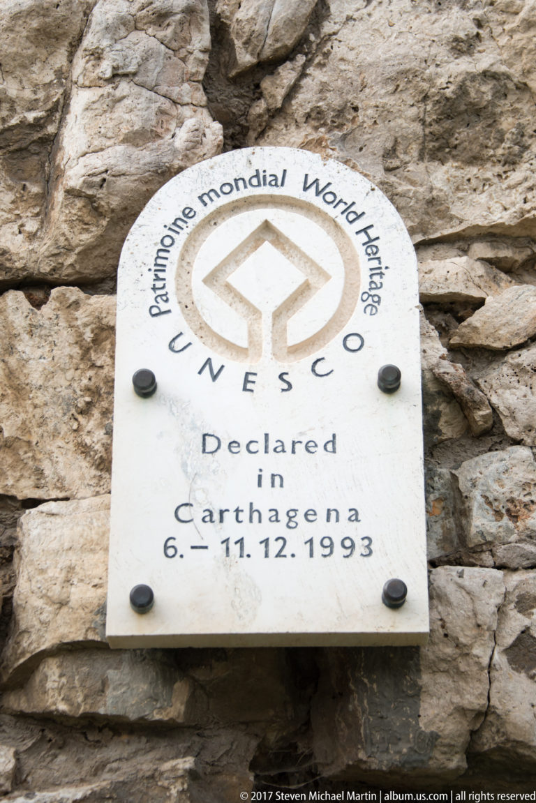 White UNESCO World Heritage plaque mounted on rough stone, with emblem and “Declared in Cartagena 6.11.1993” visible.