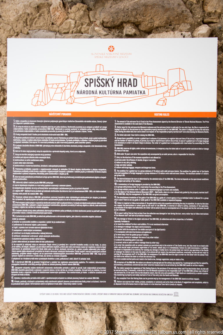 Visitor information panel headed “SPIŠSKÝ HRAD,” with a castle drawing and dense multilingual text on a stone wall.