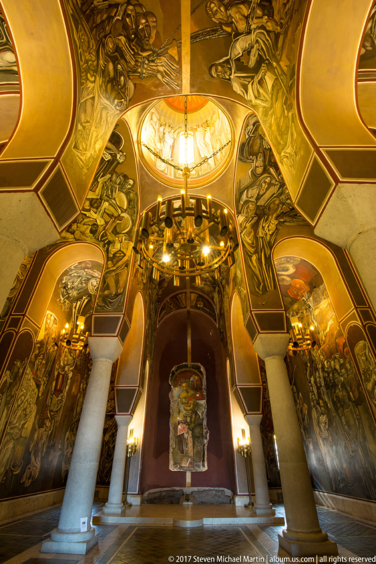 Patriarchal Church interior with pale columns, circular chandelier, painted dome, and monumental murals by Teofan Sokerov.