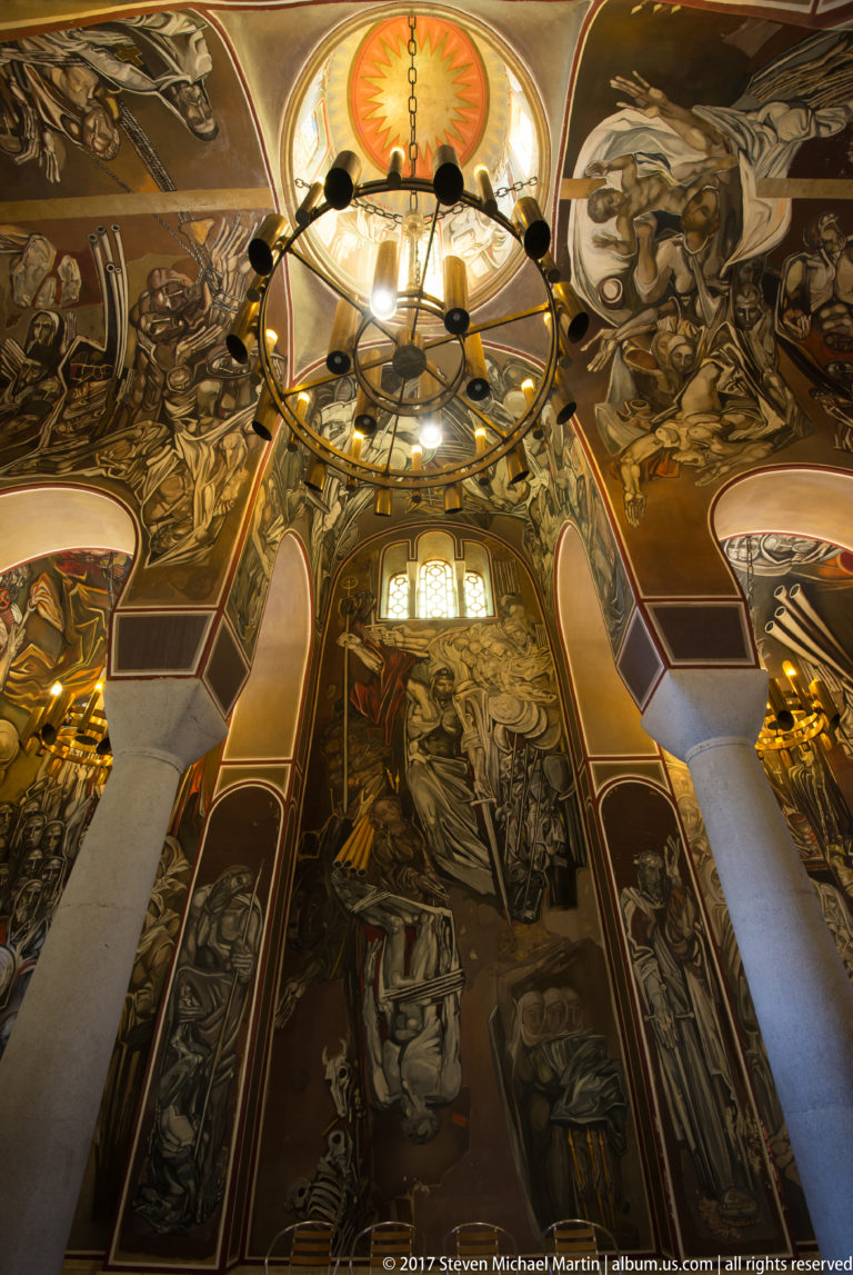 Upward view inside the Patriarchal Church with circular chandelier, painted dome, and monumental murals by Teofan Sokerov.