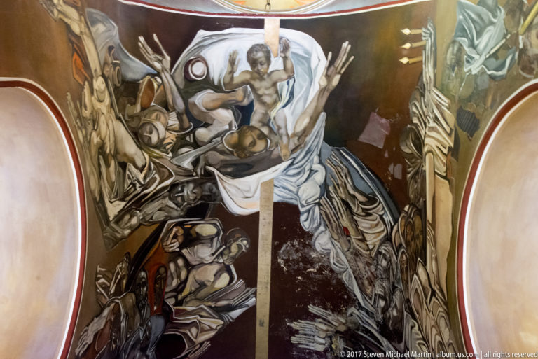 Teofan Sokerov mural with a partially draped male figure above clustered bodies and sweeping gray-white forms.