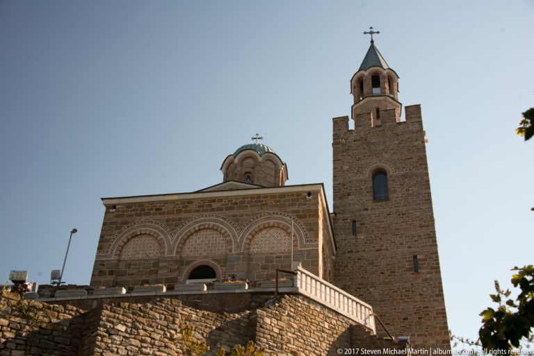 Low-angle view of the reconstructed Patriarchal Church of the Ascension of Christ with stone façade, dome, and cross-topped bell tower.