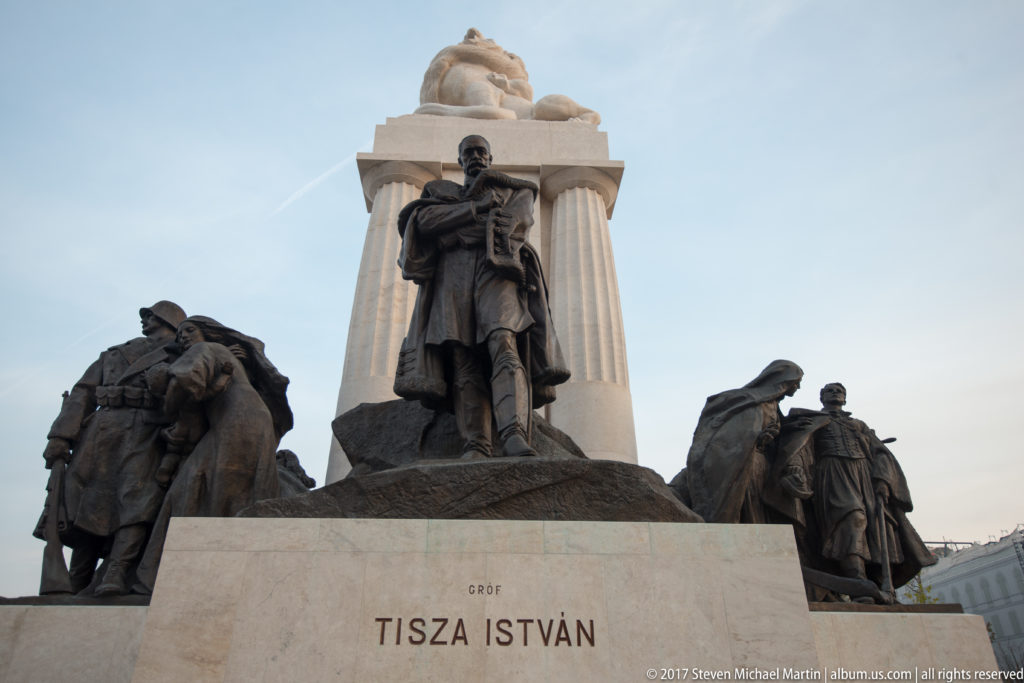 István Tisza monument with central standing bronze figure, flanking groups, and the inscription GRÓF TISZA ISTVÁN.