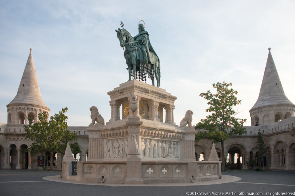 Full Saint Stephen I equestrian monument centered in the arcaded court of Fisherman’s Bastion between conical towers.